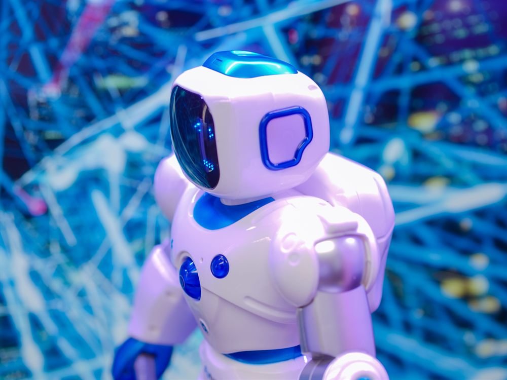 A white toy robot lit in blue and violet against a tangle of light trails
