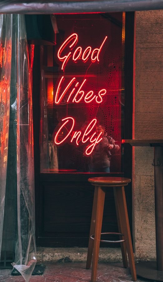 A red neon sign reading Good Vibes Only in a shop window